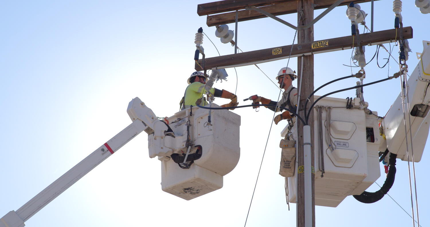 linemen conduct electrical operations from a bucket truck