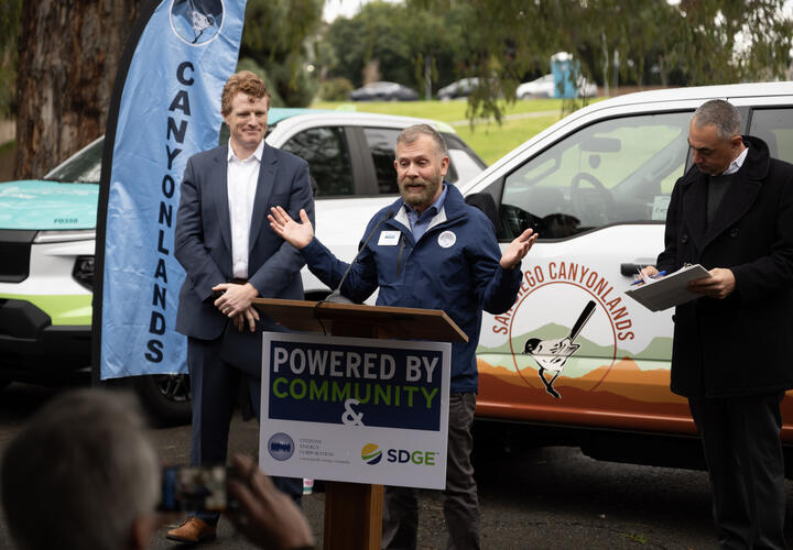 Clayton Tschudy, CEO of San Diego Canyonlands, speaks up at a podium.