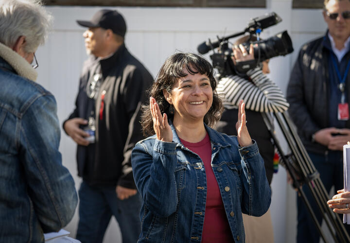 A woman claps while smiling.