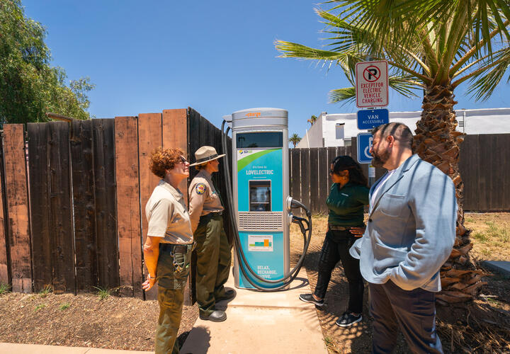 People standing around a newly installed EV charger