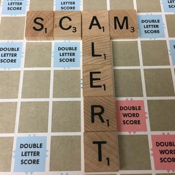 Scam alert image spelled out in Scrabble tiles