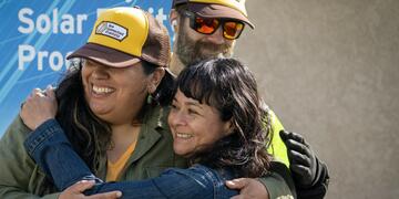 Three people hugging.