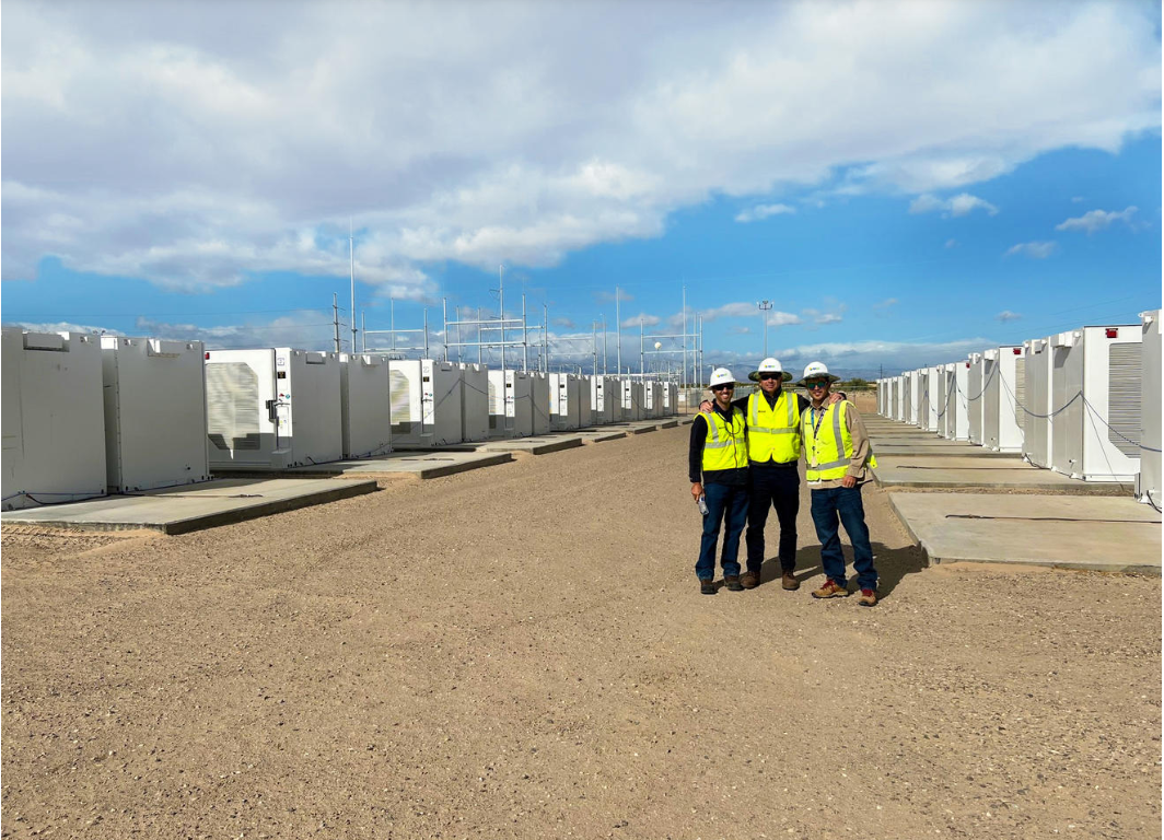 Three SDG&E employees posing for a photo in front of energy storage facilities