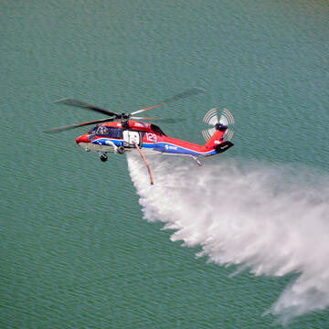 SDG&E's Black Hawk helicopter flying over a lake.