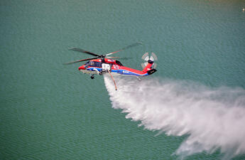 SDG&E's Black Hawk helicopter flying over a lake.