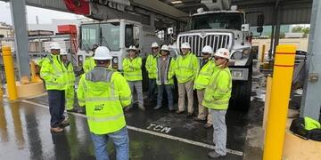 SDG&E crews in safety vests and hard hats gather for a safety briefing